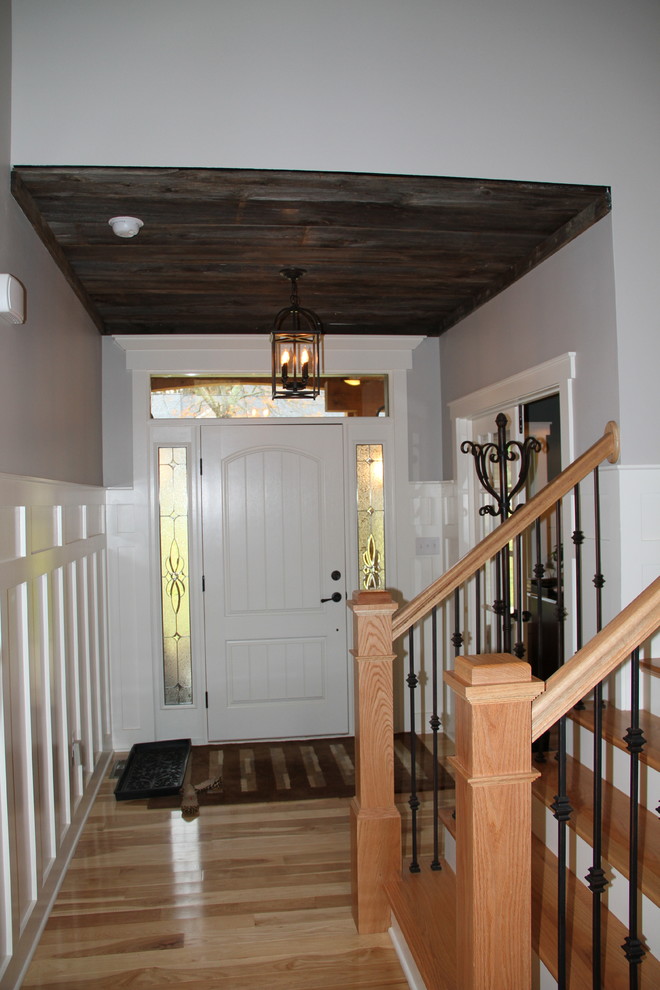 Foyer - mid-sized rustic light wood floor foyer idea with gray walls and a white front door