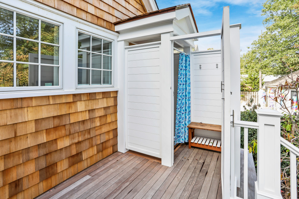 This is an example of a large beach style deck in New York with an outdoor shower and no cover.