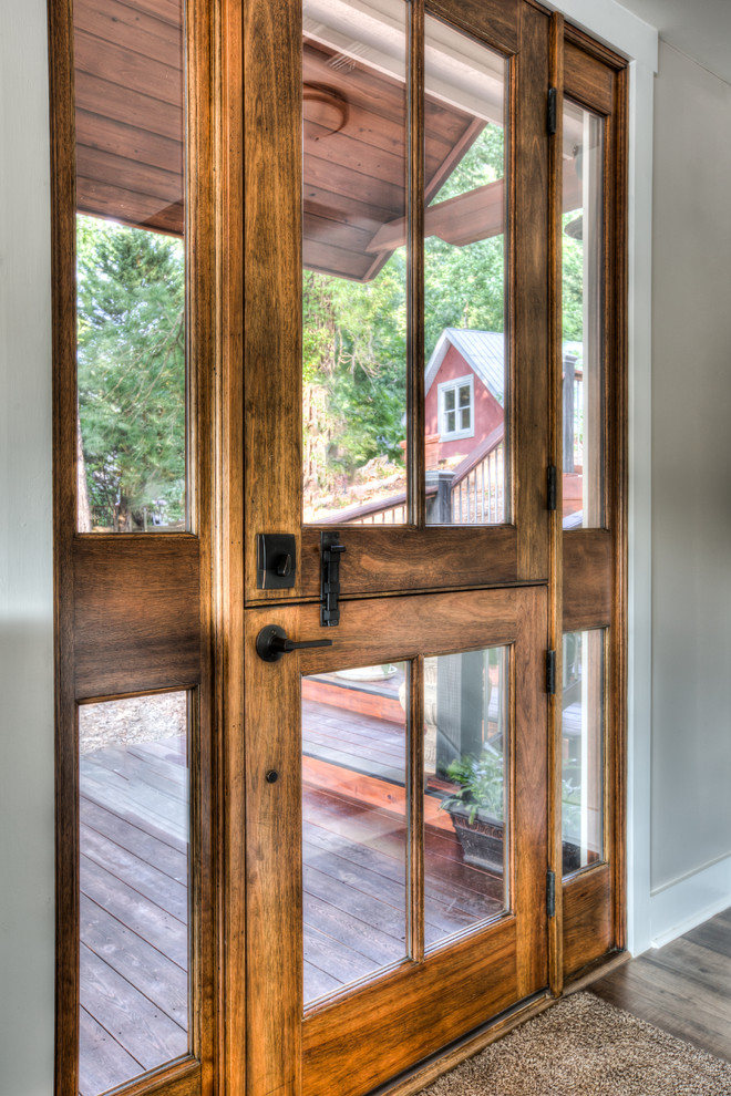 Photo of a mid-sized country front door in Other with grey walls, dark hardwood floors, a single front door, a glass front door and brown floor.