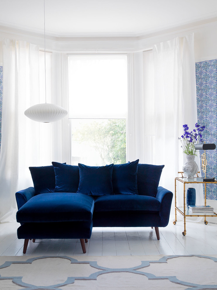 This is an example of a small contemporary living room in London with blue walls.