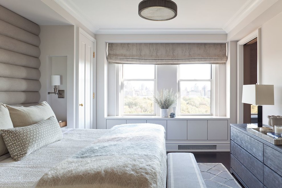 Transitional bedroom in New York with white walls and dark hardwood floors.