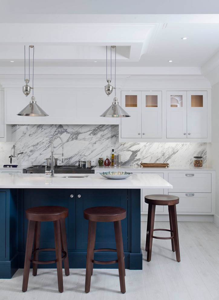 This is an example of a mid-sized transitional l-shaped open plan kitchen in Other with an undermount sink, shaker cabinets, grey cabinets, quartzite benchtops, grey splashback, marble splashback, stainless steel appliances, light hardwood floors, with island and white floor.