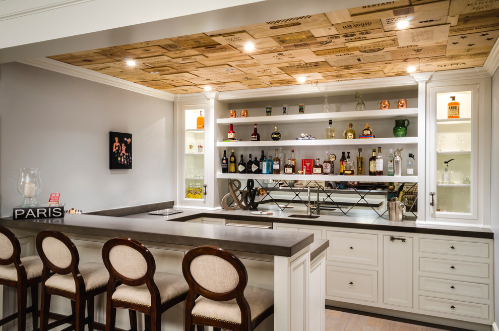 Inspiration for a transitional u-shaped seated home bar in Cleveland with open cabinets and concrete benchtops.