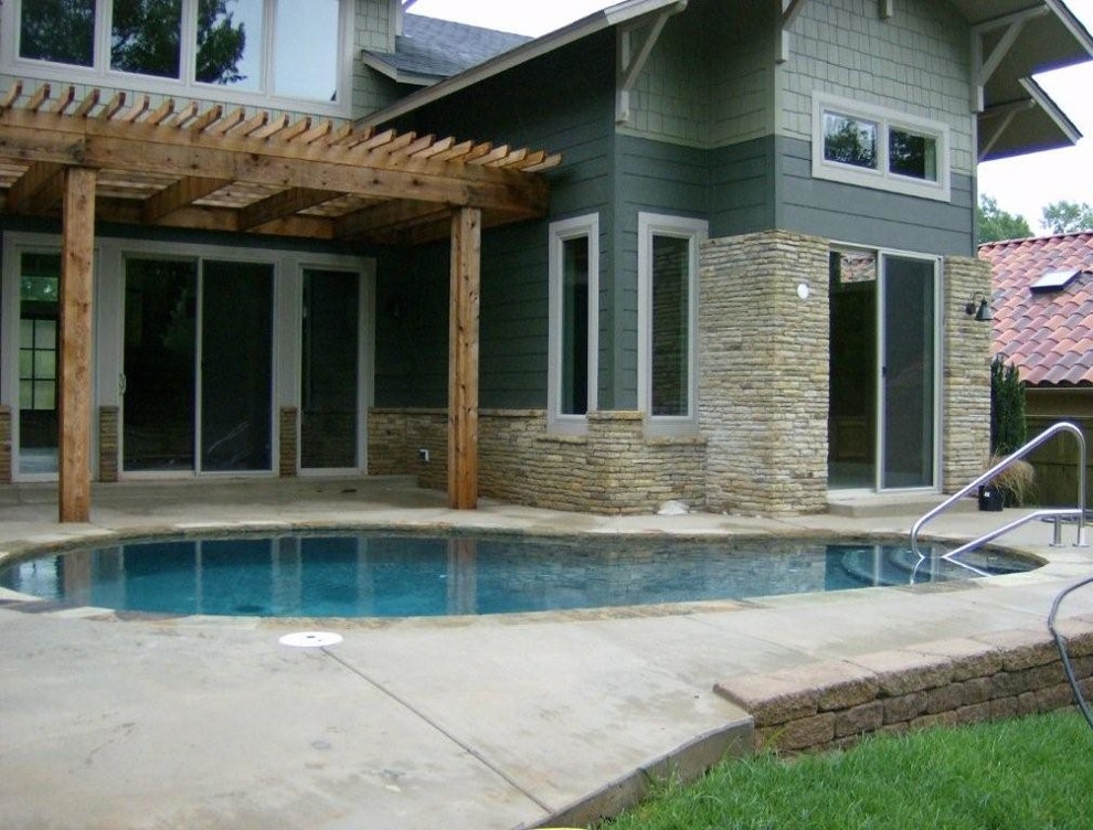 Small transitional backyard kidney-shaped pool in Oklahoma City with concrete slab.