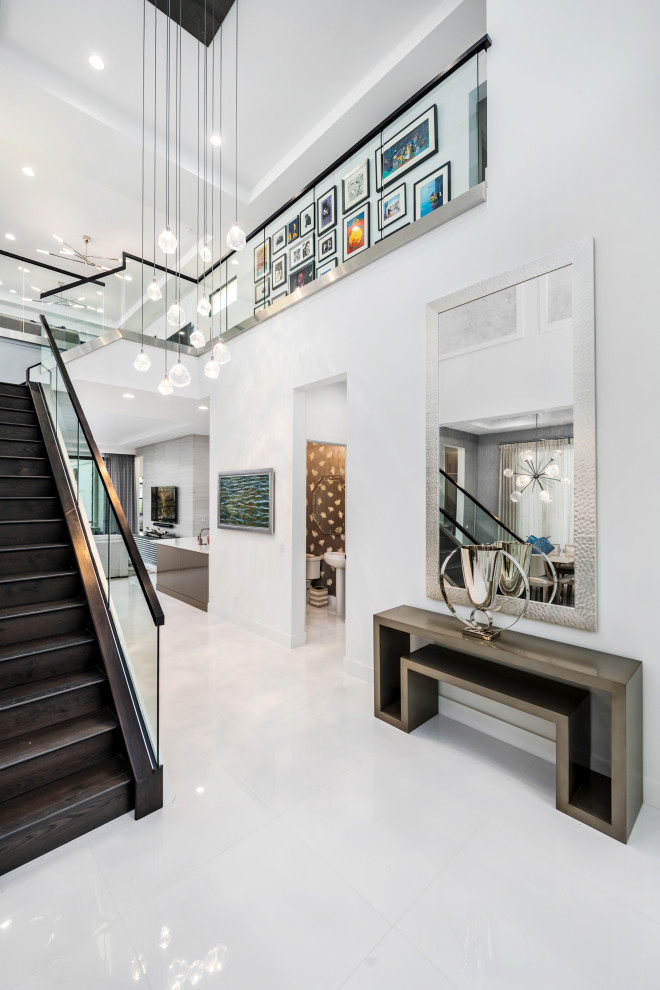 Inspiration for an expansive contemporary entry hall in Miami with white walls, marble floors, white floor and vaulted.