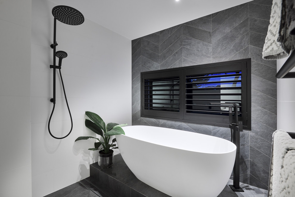 Photo of a contemporary master bathroom in Perth with flat-panel cabinets, black cabinets, a freestanding tub, an open shower, white tile, porcelain floors, tile benchtops, grey floor, an open shower, white benchtops, a double vanity and a floating vanity.