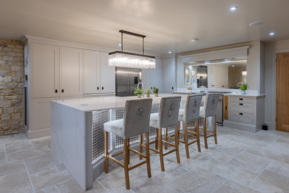 Inspiration for a mid-sized modern galley porcelain tile and beige floor eat-in kitchen remodel in West Midlands with a farmhouse sink, shaker cabinets, gray cabinets, quartzite countertops, white backsplash, mirror backsplash, black appliances, an island and white countertops