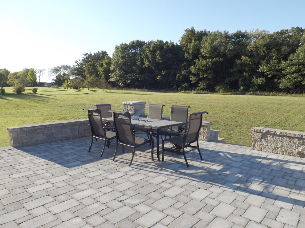 Large contemporary backyard patio in Chicago with a fire feature, brick pavers and no cover.