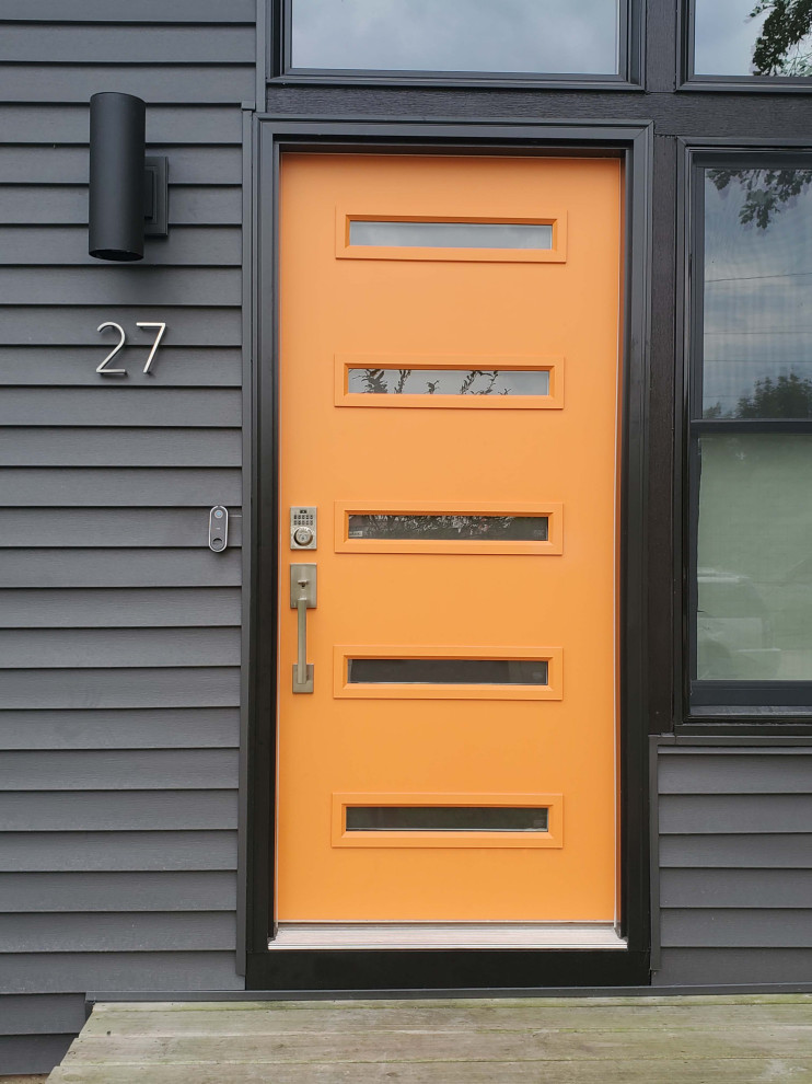 На фото: входная дверь среднего размера с черными стенами, одностворчатой входной дверью и оранжевой входной дверью