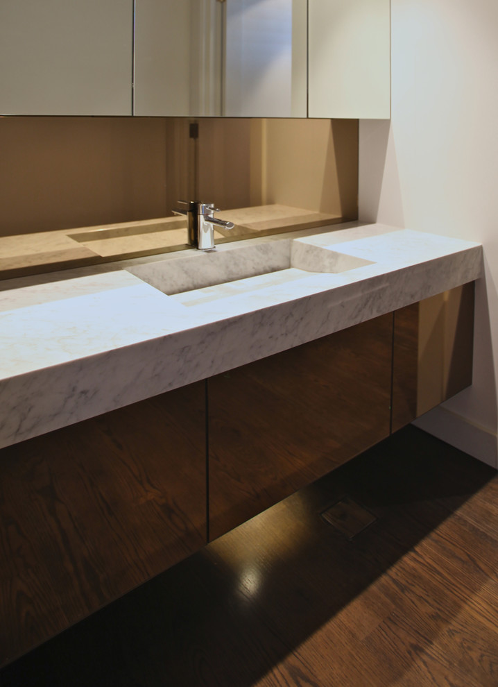 Photo of a transitional bathroom in Perth with flat-panel cabinets, dark wood cabinets, white walls, an integrated sink and marble benchtops.