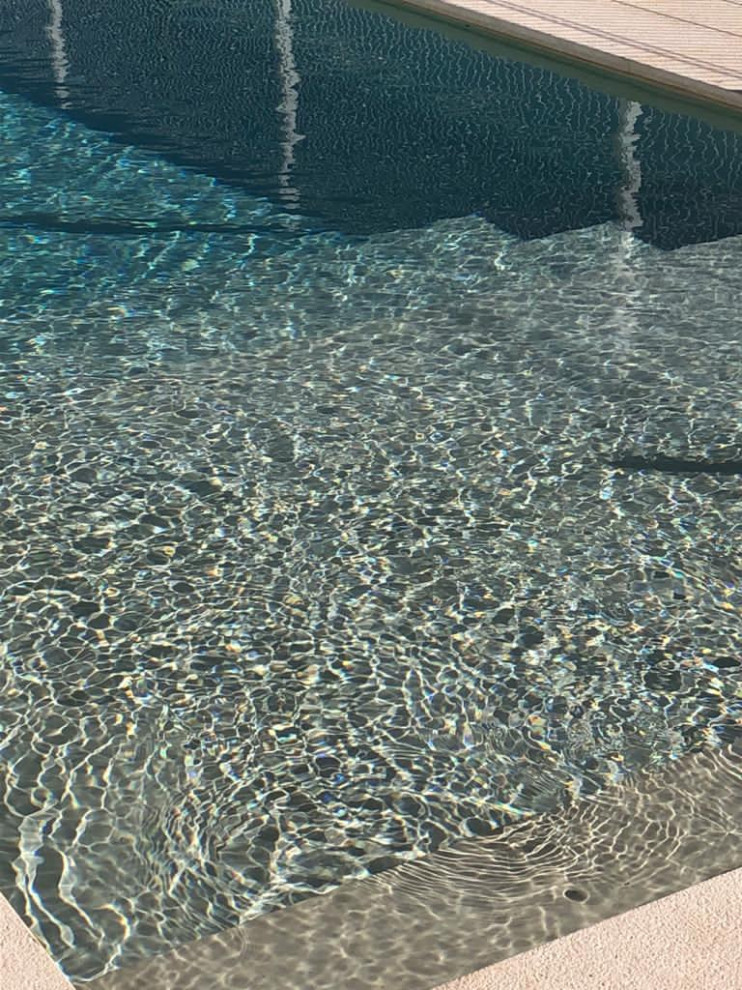Immagine di una piscina naturale stile marinaro rettangolare di medie dimensioni e sul tetto con pavimentazioni in pietra naturale
