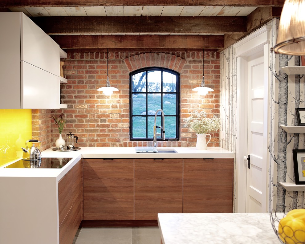 Inspiration for a mid-sized eclectic l-shaped eat-in kitchen in Other with an undermount sink, flat-panel cabinets, medium wood cabinets, quartz benchtops, brown splashback, brick splashback, concrete floors, no island and grey floor.