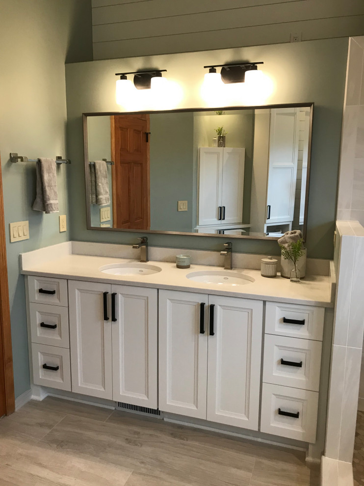 Large transitional master bathroom in Milwaukee with flat-panel cabinets, white cabinets, a freestanding tub, a corner shower, a two-piece toilet, white tile, porcelain tile, green walls, porcelain floors, an undermount sink, engineered quartz benchtops, grey floor, a hinged shower door, white benchtops, a niche, a double vanity, a built-in vanity, vaulted and planked wall panelling.