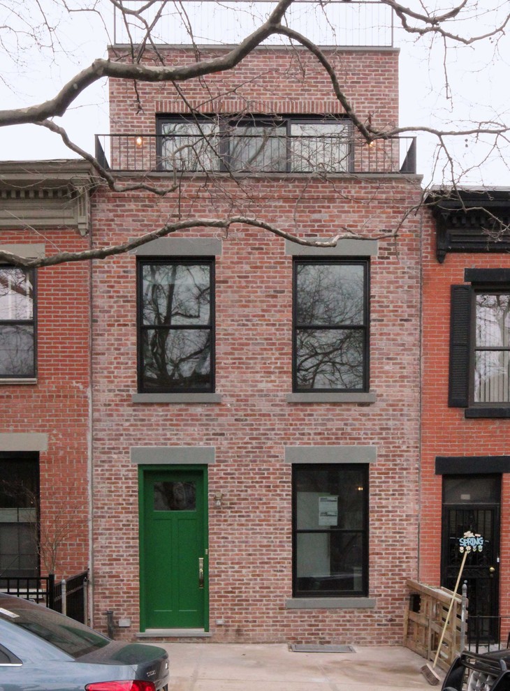 Inspiration for a mid-sized modern three-storey brick red townhouse exterior in New York with a flat roof.