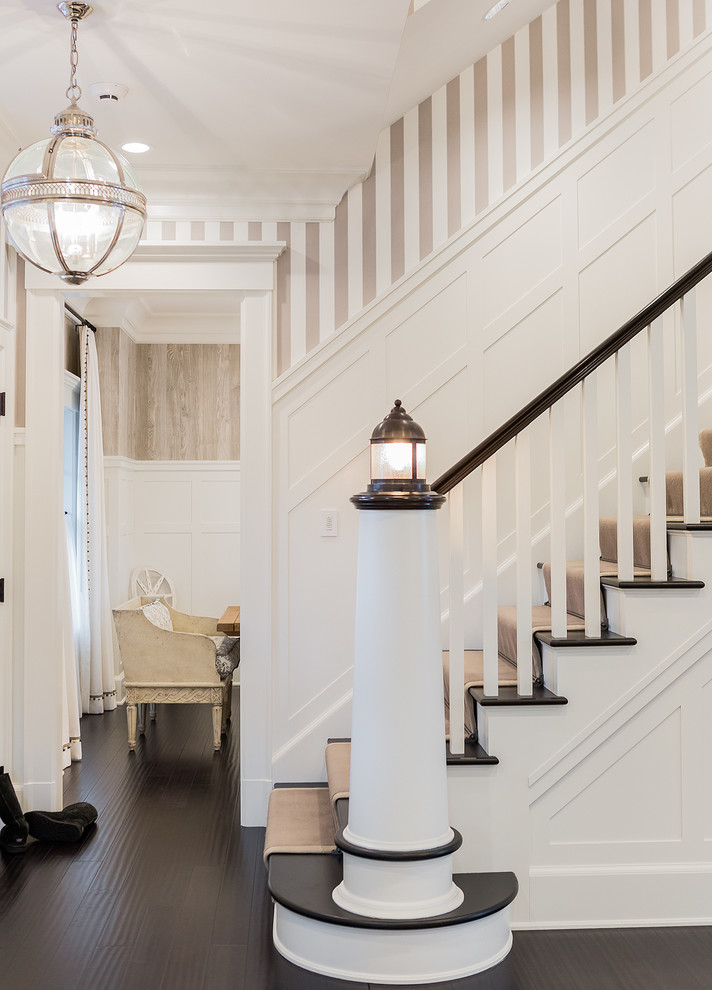 Beach style wood straight staircase in Boston with painted wood risers.