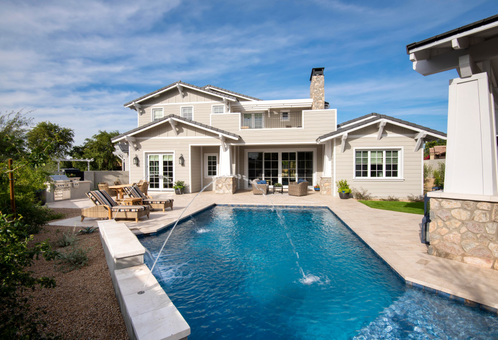 Pool house - large transitional backyard stone and custom-shaped pool house idea in Phoenix