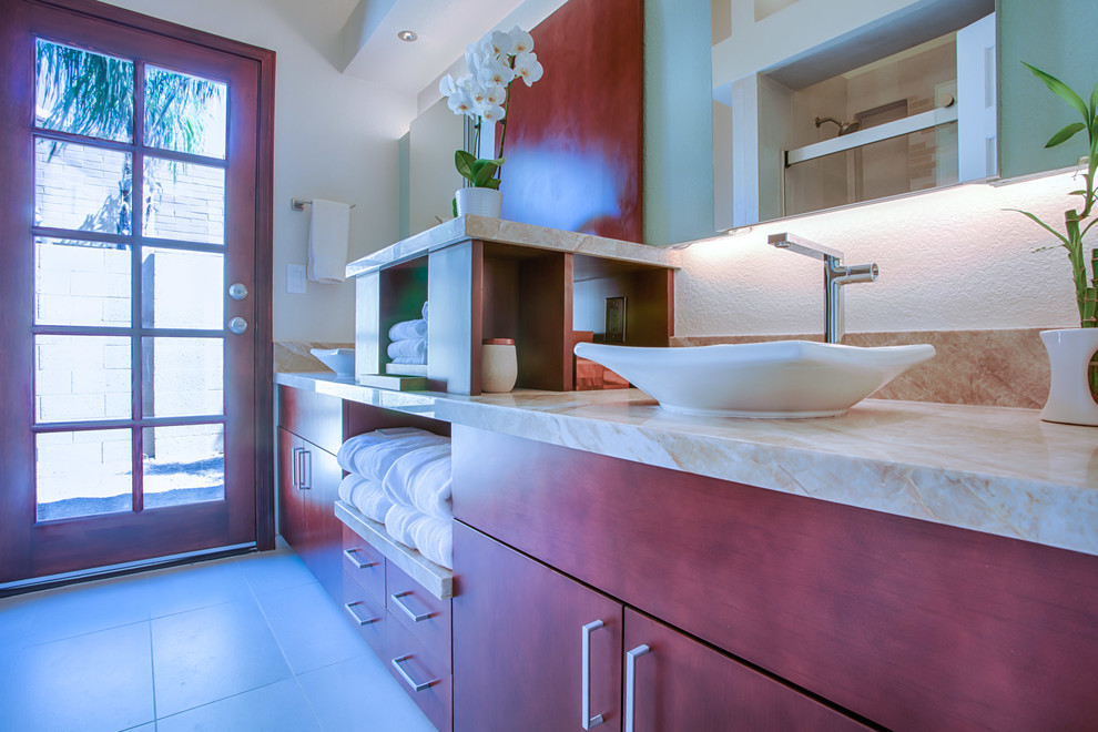 Small transitional beige tile and porcelain tile porcelain tile and beige floor alcove bathtub photo in Phoenix with flat-panel cabinets, medium tone wood cabinets, a one-piece toilet, beige walls, a vessel sink and granite countertops