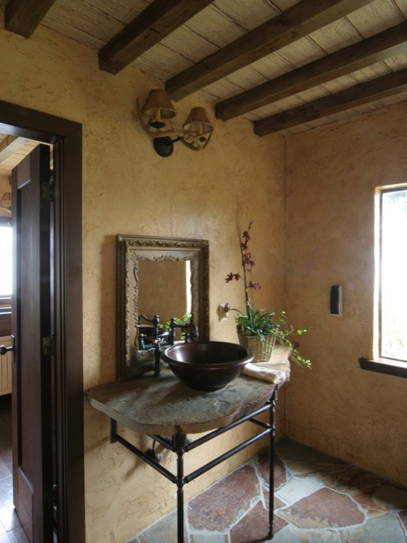 Photo of a mid-sized master bathroom in Other with open cabinets, a freestanding tub, a shower/bathtub combo, a two-piece toilet, beige walls, slate floors, a vessel sink, solid surface benchtops, multi-coloured floor, a shower curtain and multi-coloured benchtops.