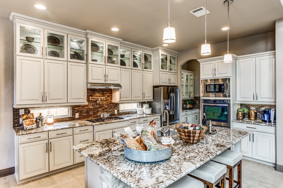 Design ideas for a mid-sized traditional l-shaped open plan kitchen in Atlanta with an undermount sink, raised-panel cabinets, white cabinets, granite benchtops, stainless steel appliances and ceramic floors.
