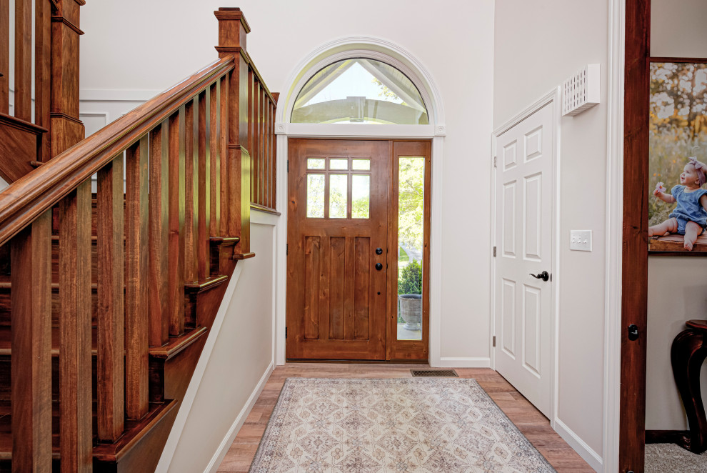 Идея дизайна: входная дверь среднего размера в классическом стиле с бежевыми стенами, одностворчатой входной дверью, входной дверью из дерева среднего тона, паркетным полом среднего тона и бежевым полом