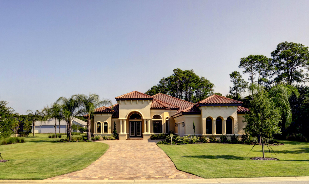 Photo of an expansive transitional front yard partial sun driveway for summer in Orlando with concrete pavers.