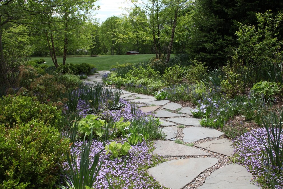 This is an example of a large traditional backyard garden in Newark with natural stone pavers.