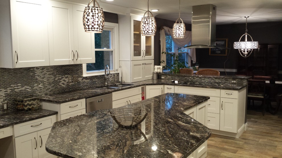 Example of a mid-sized transitional l-shaped light wood floor eat-in kitchen design in New York with a double-bowl sink, shaker cabinets, white cabinets, gray backsplash, mosaic tile backsplash, stainless steel appliances, a peninsula and granite countertops