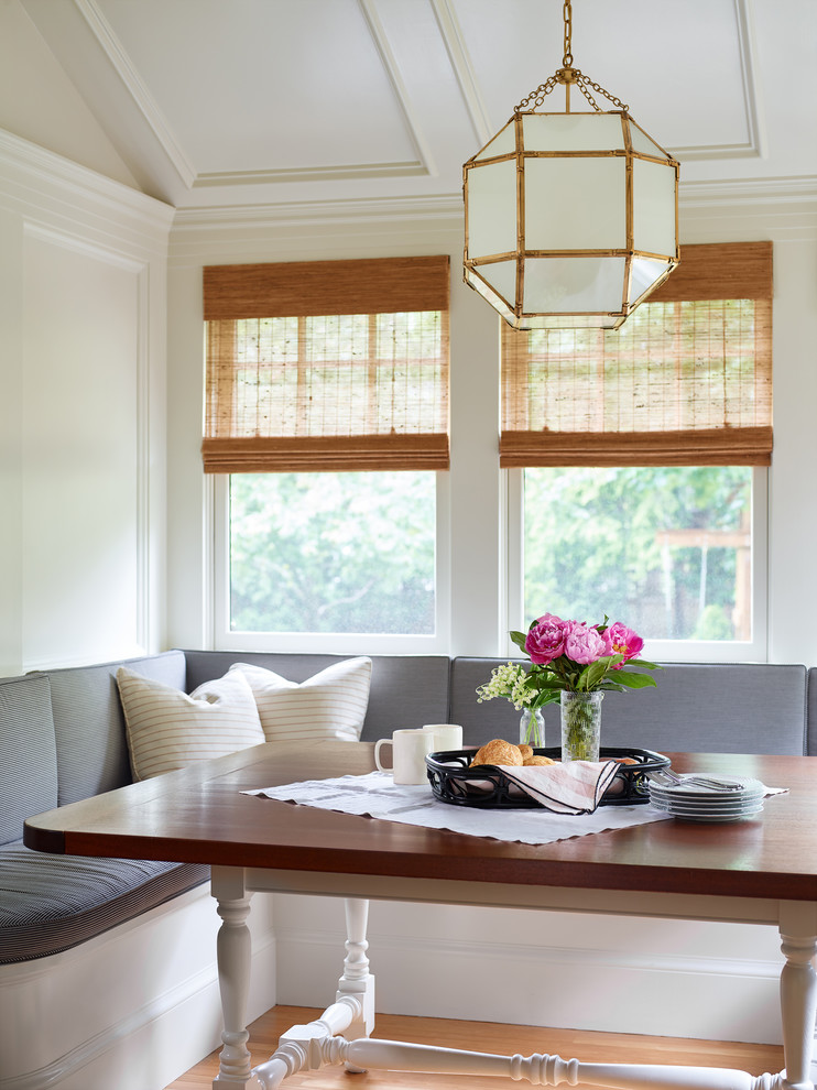 This is an example of a small traditional dining room in Boston with white walls and light hardwood floors.