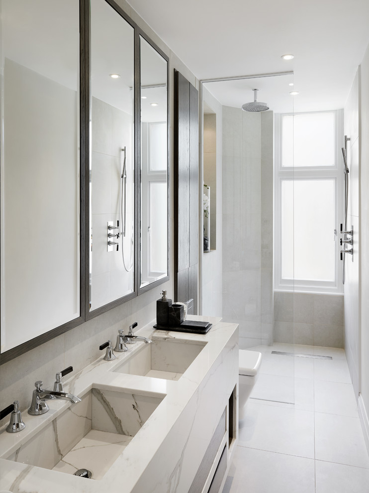 Photo of a mid-sized modern wet room bathroom in London with a one-piece toilet, gray tile, grey walls, an integrated sink, marble benchtops, grey floor and an open shower.