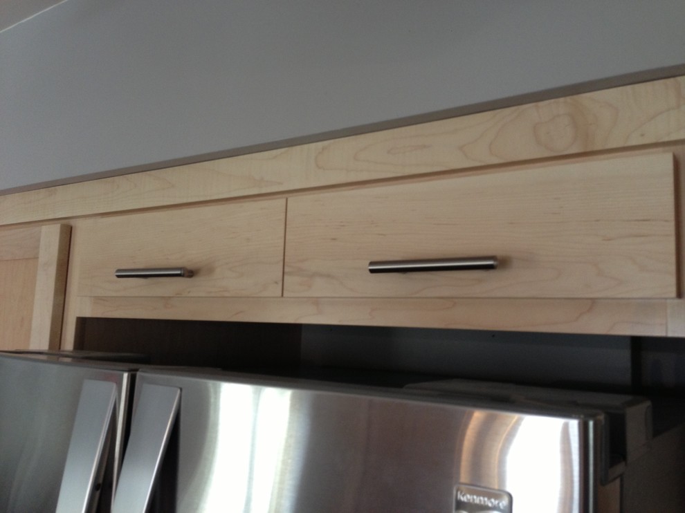 Example of a small transitional u-shaped medium tone wood floor enclosed kitchen design in Chicago with a double-bowl sink, shaker cabinets, light wood cabinets, quartzite countertops, stainless steel appliances and a peninsula