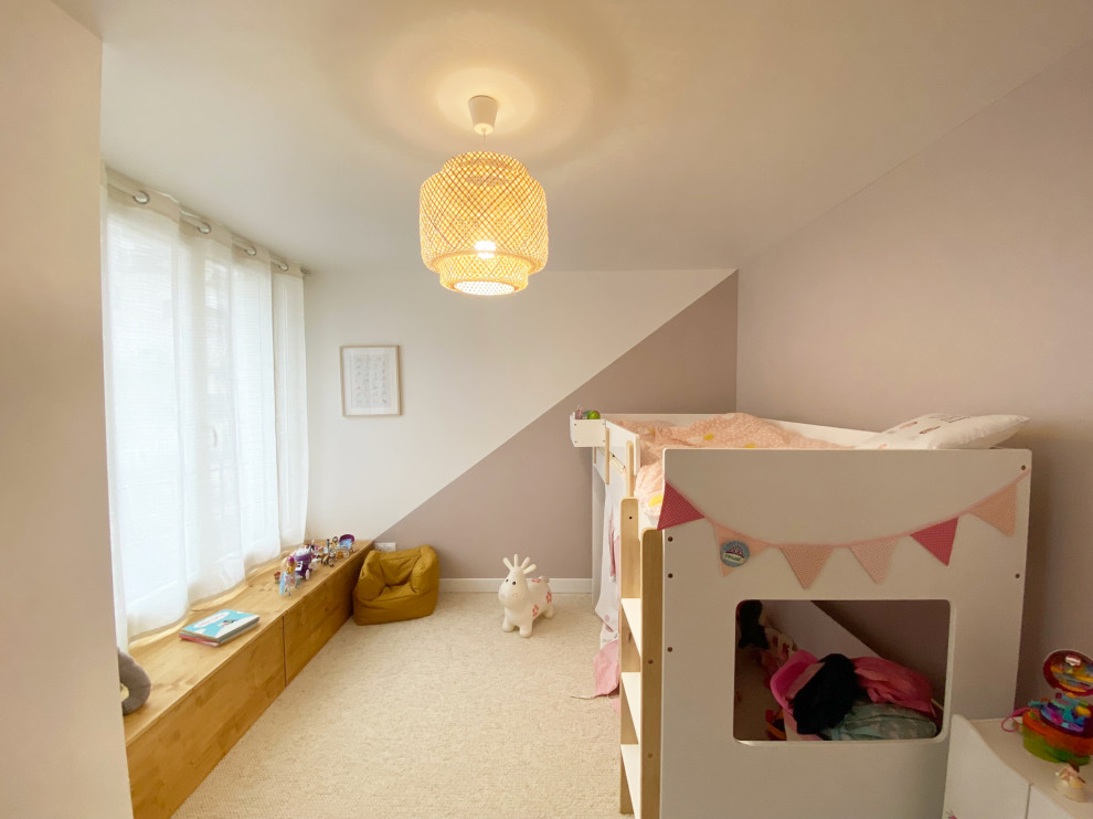 This is an example of a medium sized classic children’s room for girls in Paris with pink walls, carpet and beige floors.