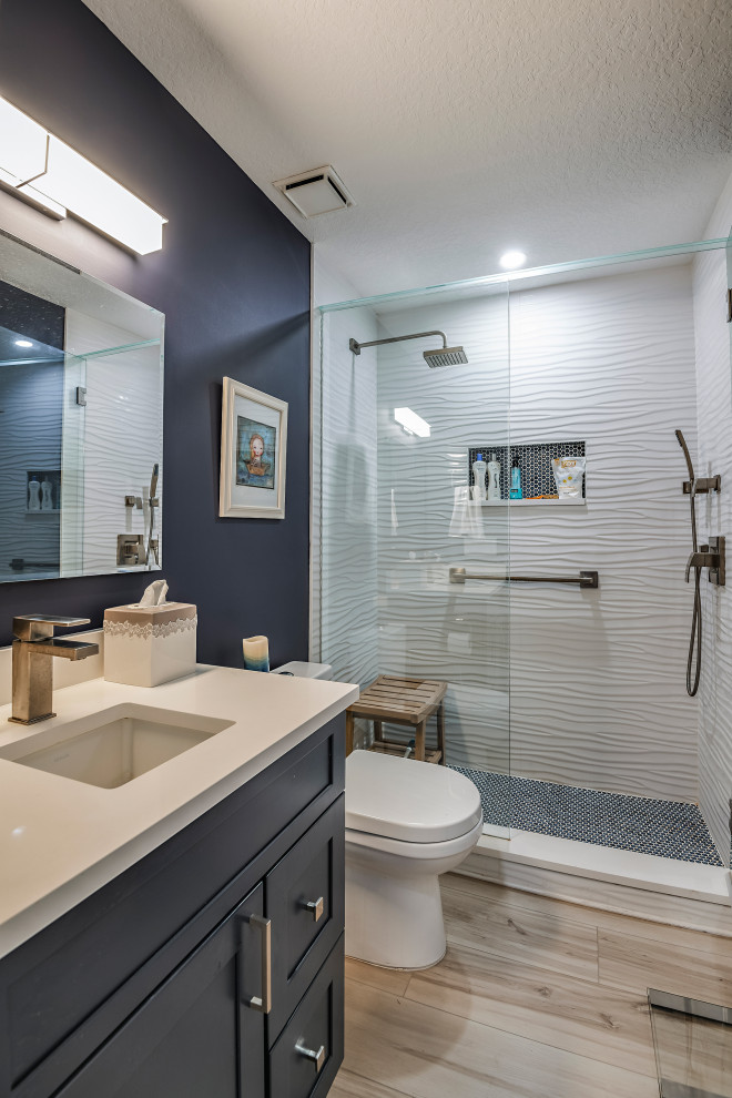タンパにある高級なビーチスタイルのおしゃれなバスルーム (浴槽なし) (フラットパネル扉のキャビネット、青いキャビネット、クオーツストーンの洗面台、白い洗面カウンター、洗面台1つ、造り付け洗面台) の写真
