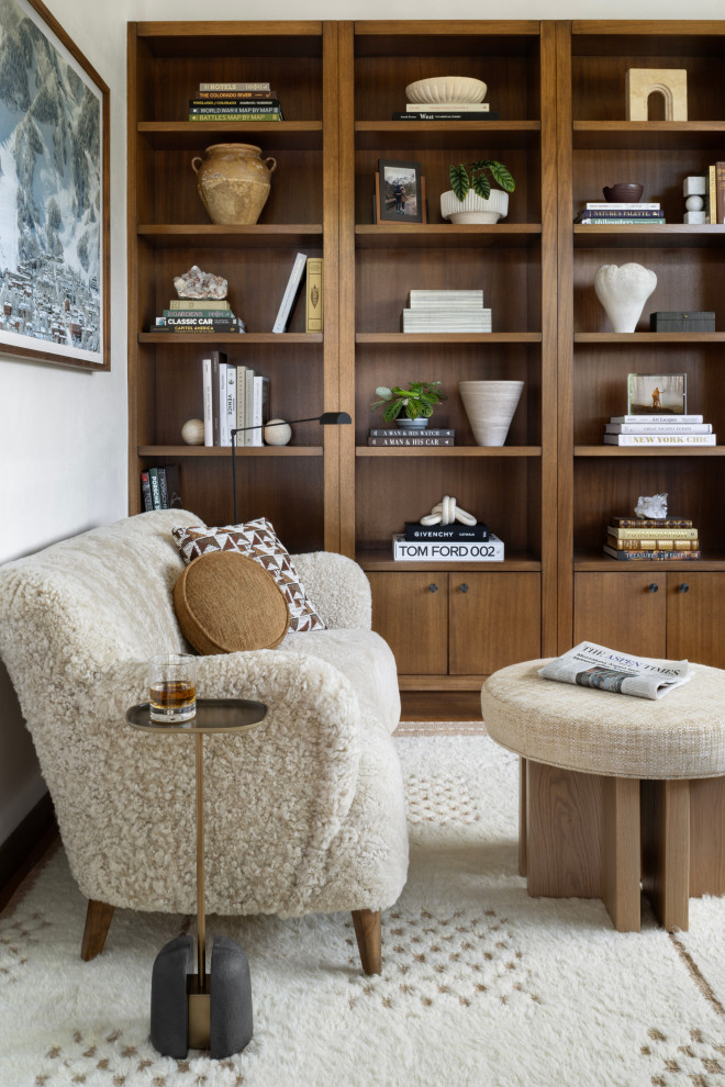Example of a mid-sized minimalist enclosed carpeted and white floor family room library design in Denver with white walls and no tv