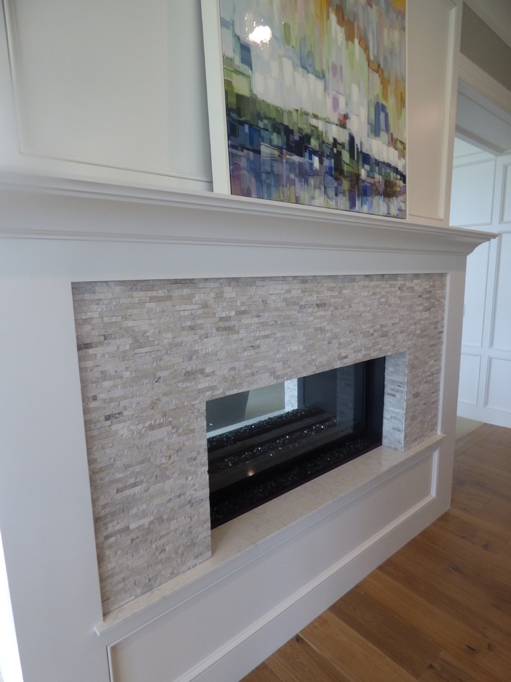 Example of a large transitional l-shaped light wood floor eat-in kitchen design with an undermount sink, recessed-panel cabinets, white cabinets, quartz countertops, white backsplash, subway tile backsplash, stainless steel appliances and an island