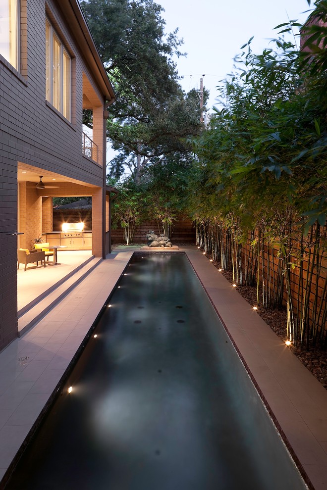 Photo of a mid-sized contemporary side yard rectangular pool in Houston with tile.