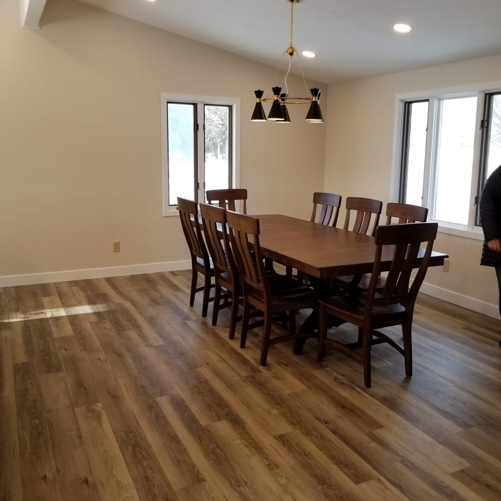 This is an example of a large transitional kitchen/dining combo in Milwaukee with vinyl floors, brown floor and vaulted.