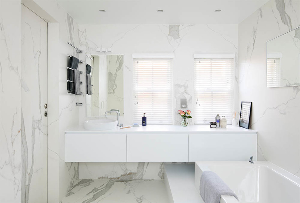 Large contemporary master bathroom in Oxfordshire with an open shower, flat-panel cabinets, porcelain floors, white cabinets, a drop-in tub, white tile, white benchtops, a single vanity and a floating vanity.
