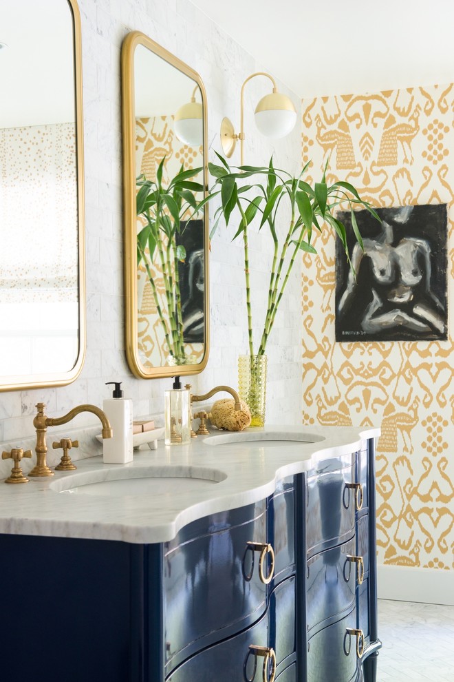 This is an example of a large eclectic master bathroom in New York with furniture-like cabinets, blue cabinets, a claw-foot tub, a corner shower, white tile, stone tile, marble floors, an undermount sink, marble benchtops, multi-coloured walls and grey floor.