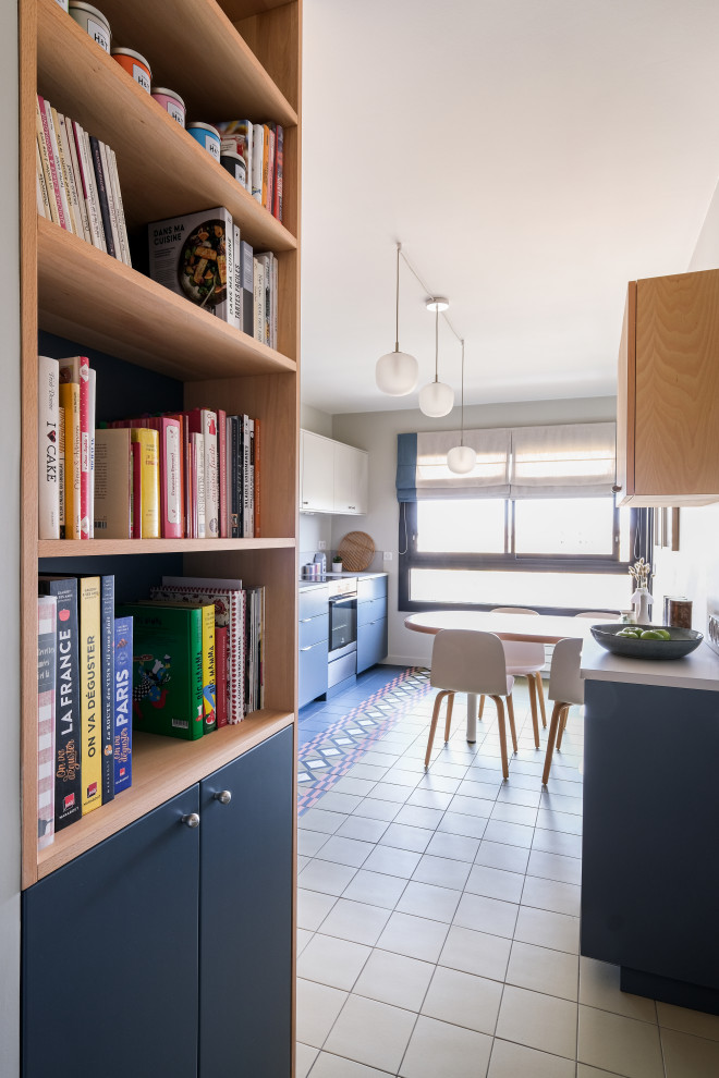 Exemple d'une cuisine linéaire tendance de taille moyenne avec un placard à porte plane, des portes de placard bleues, carreaux de ciment au sol, un sol multicolore, un plan de travail gris et machine à laver.