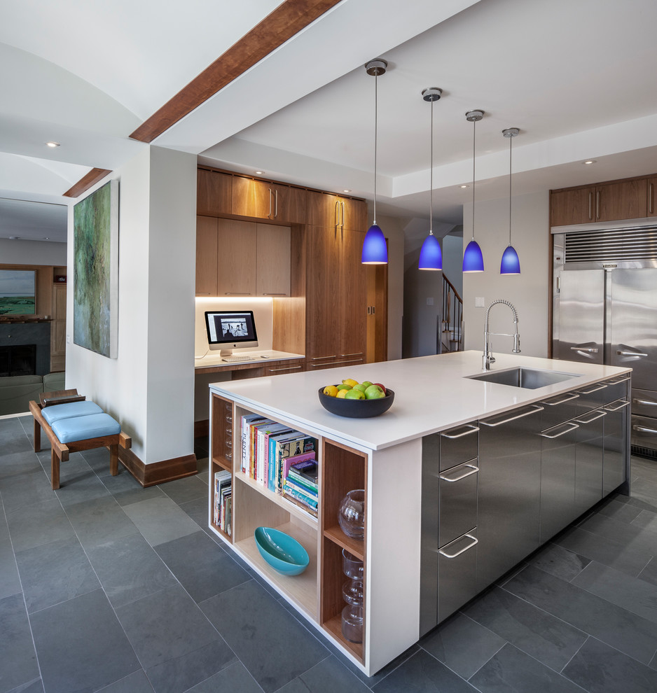 This is an example of a contemporary u-shaped kitchen in Toronto with an undermount sink, flat-panel cabinets, dark wood cabinets, stainless steel appliances, with island and grey floor.