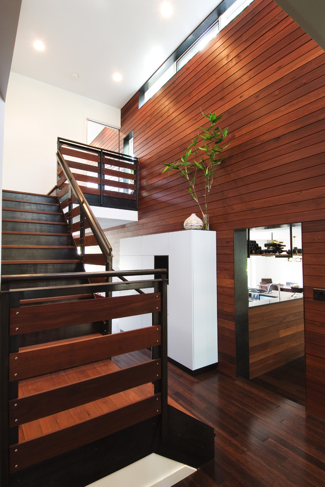 This is an example of a large modern wood l-shaped staircase in Austin with metal risers.