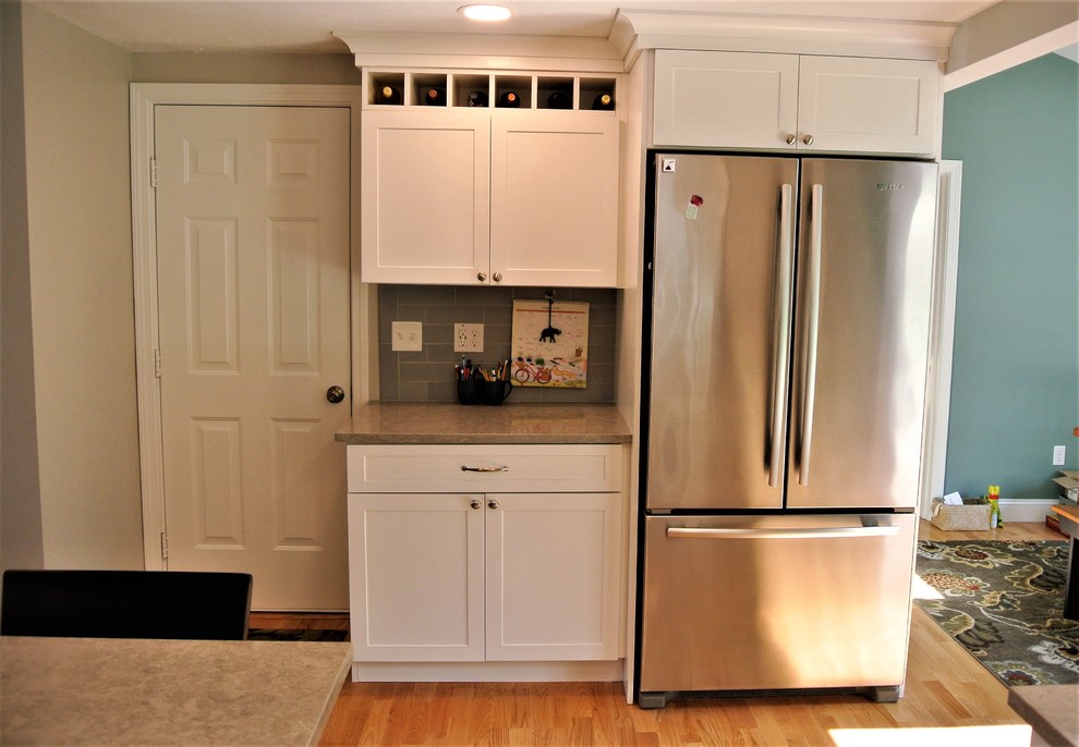 Kitchen - transitional light wood floor kitchen idea in Boston with an undermount sink, shaker cabinets, white cabinets, quartz countertops, gray backsplash, subway tile backsplash, stainless steel appliances, an island and gray countertops