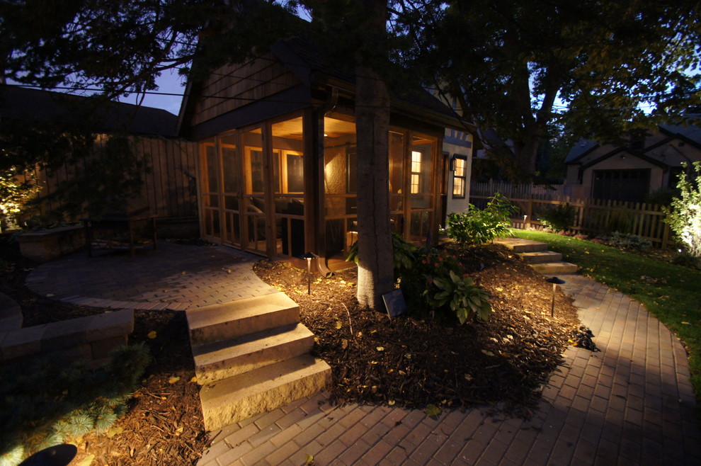 Mid-sized country backyard screened-in verandah in Minneapolis with natural stone pavers and a roof extension.
