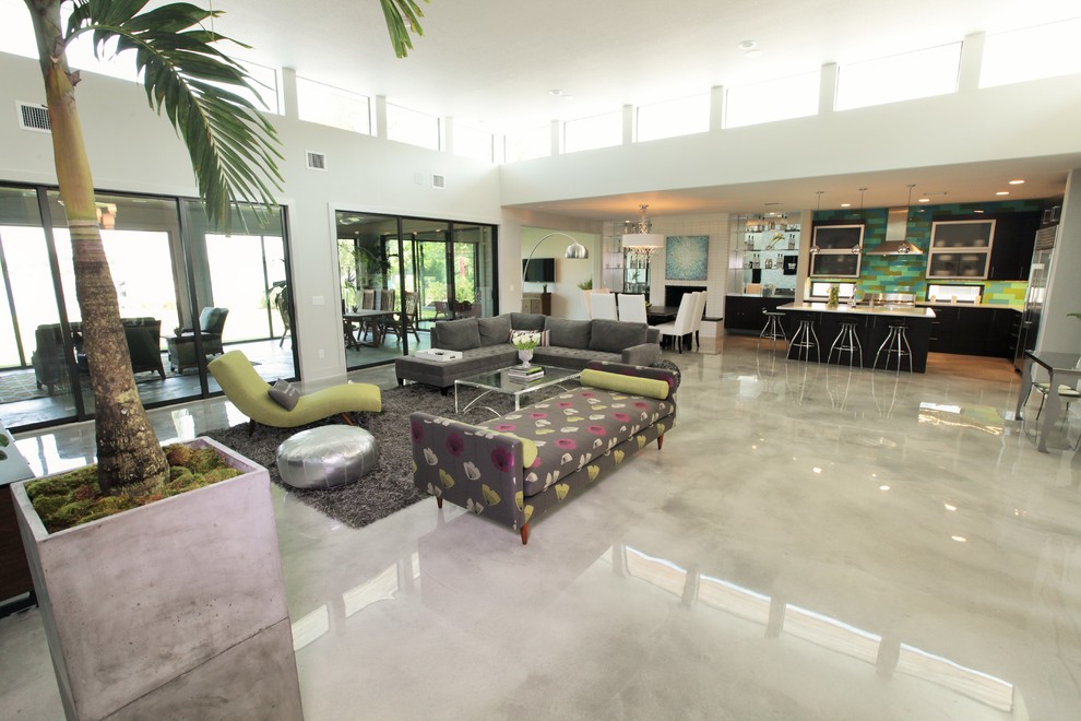Photo of an expansive contemporary formal open concept living room in Orlando with white walls, concrete floors, a standard fireplace, a brick fireplace surround, multi-coloured floor and a wall-mounted tv.
