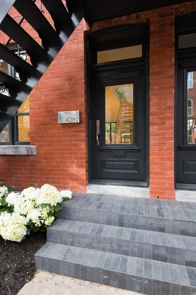 Design ideas for a small contemporary front door in Montreal with red walls, slate floors, a single front door, a black front door and black floor.