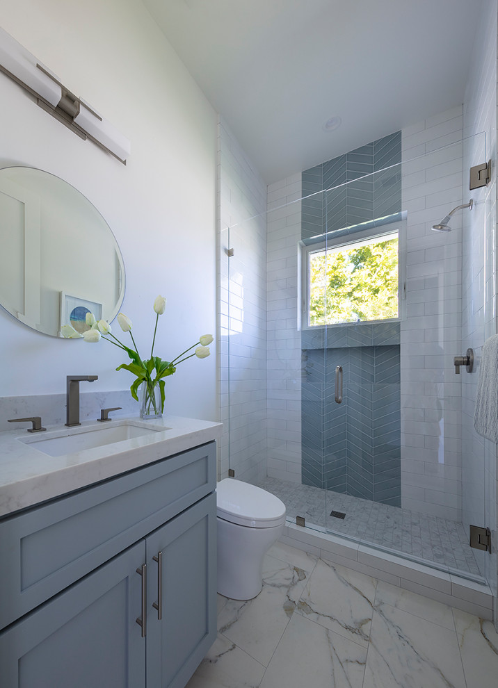 This is an example of a small country kids bathroom in San Francisco with shaker cabinets, grey cabinets, an alcove shower, a one-piece toilet, white tile, ceramic tile, white walls, porcelain floors, an undermount sink, engineered quartz benchtops, white floor, a hinged shower door and white benchtops.