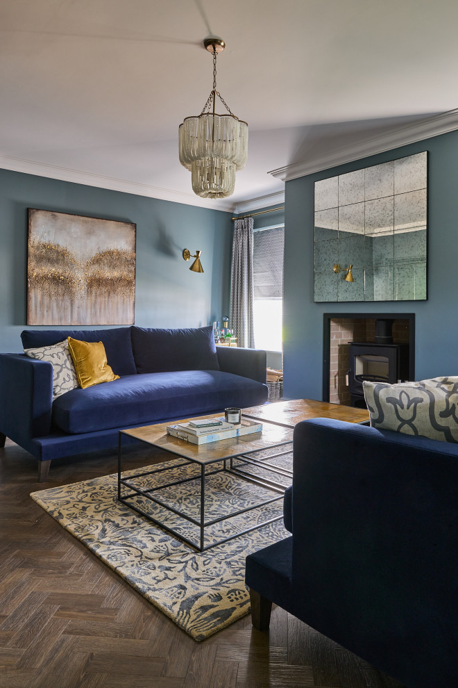 Réalisation d'un grand salon design fermé avec une salle de réception, un mur bleu, parquet foncé, un poêle à bois, un manteau de cheminée en plâtre, un téléviseur fixé au mur et un sol marron.