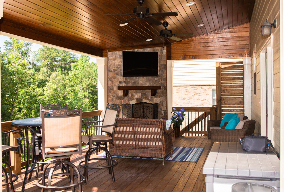 This is an example of an arts and crafts backyard verandah in Atlanta with with fireplace and a roof extension.