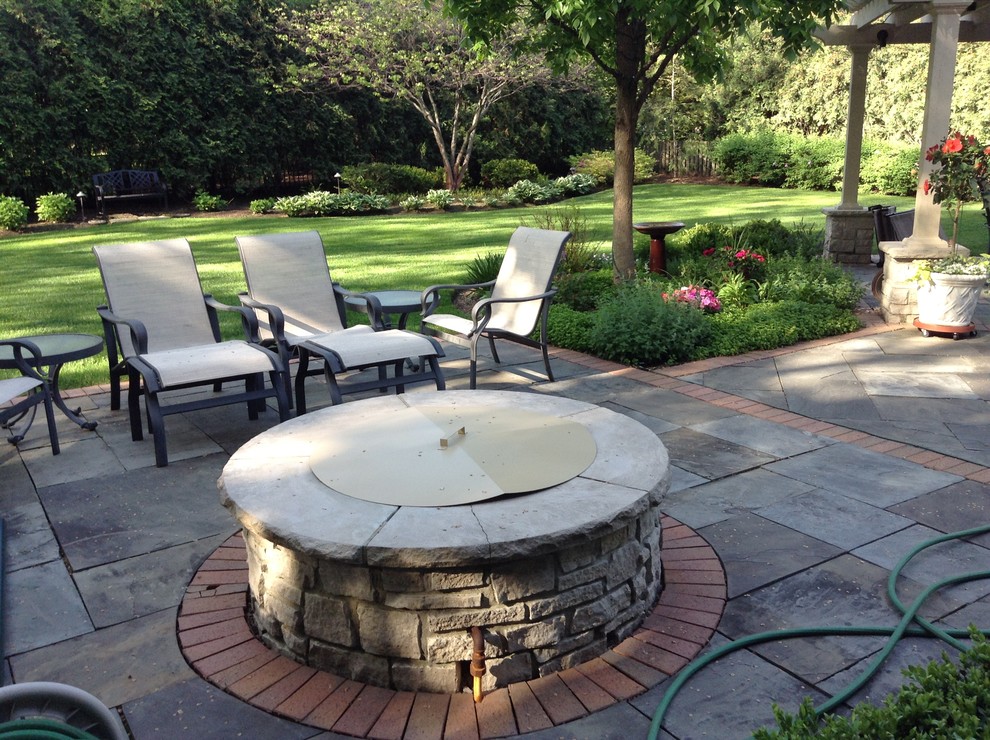 Inspiration for a large traditional backyard patio in Other with a fire feature and a pergola.