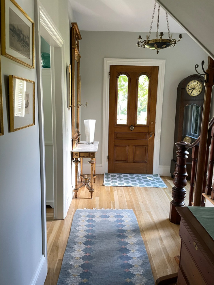Mid-sized danish medium tone wood floor entryway photo in Providence with gray walls and a medium wood front door
